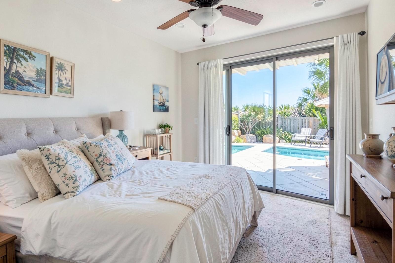 Primary bedroom with sliding doors opening to the pool deck