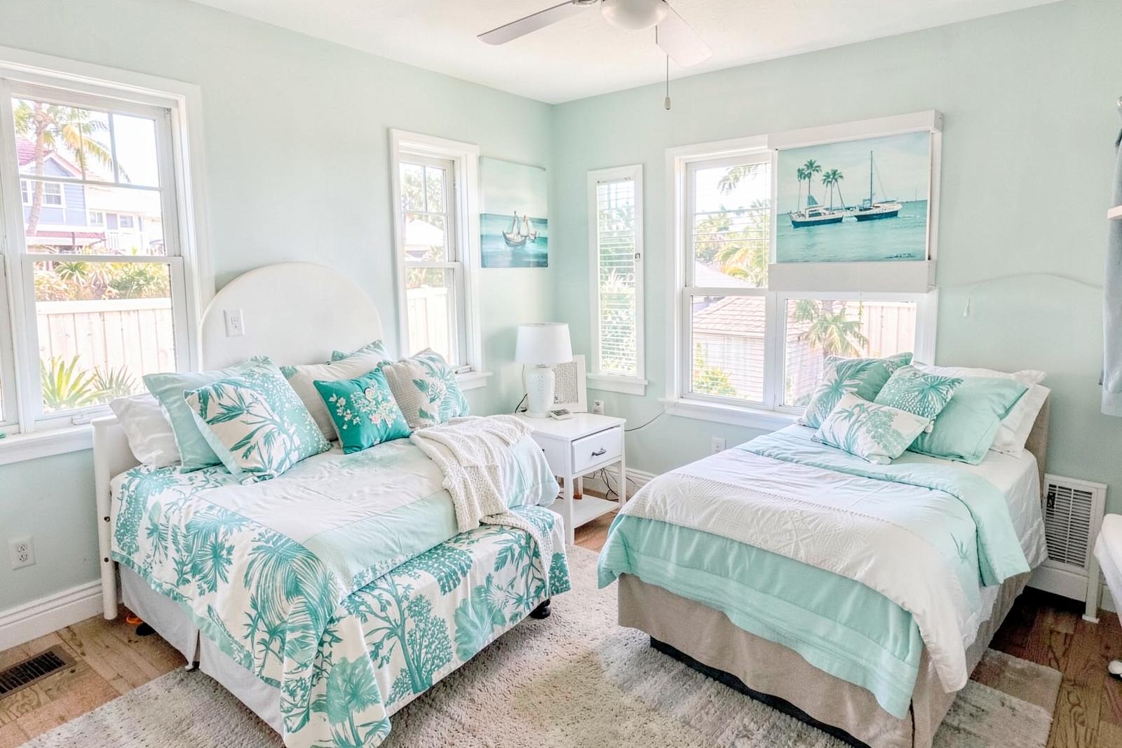 Twin bedroom with bright windows and aqua accents