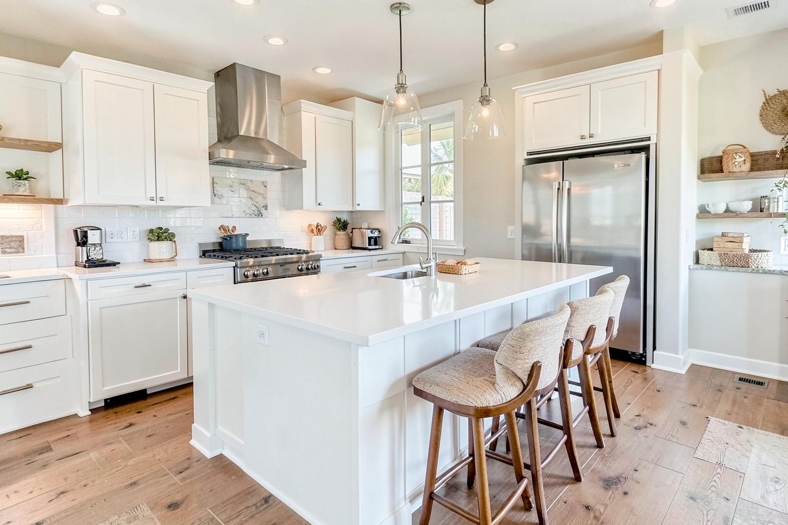 Open kitchen with large quartz island, bar seating and stainless appliances